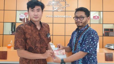 Kepala Kantor Pos Cabang Gresik Maestro Yunan saat memberikan BSU kepada pekerja penerima,Jumat (2/12/2022).