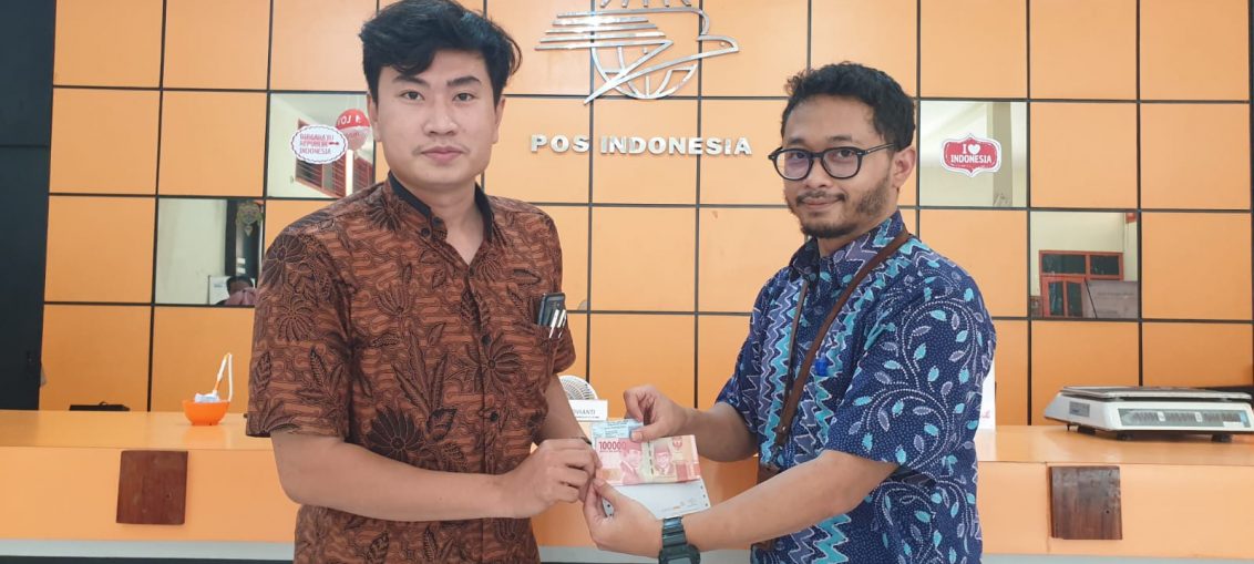 Kepala Kantor Pos Cabang Gresik Maestro Yunan saat memberikan BSU kepada pekerja penerima,Jumat (2/12/2022).