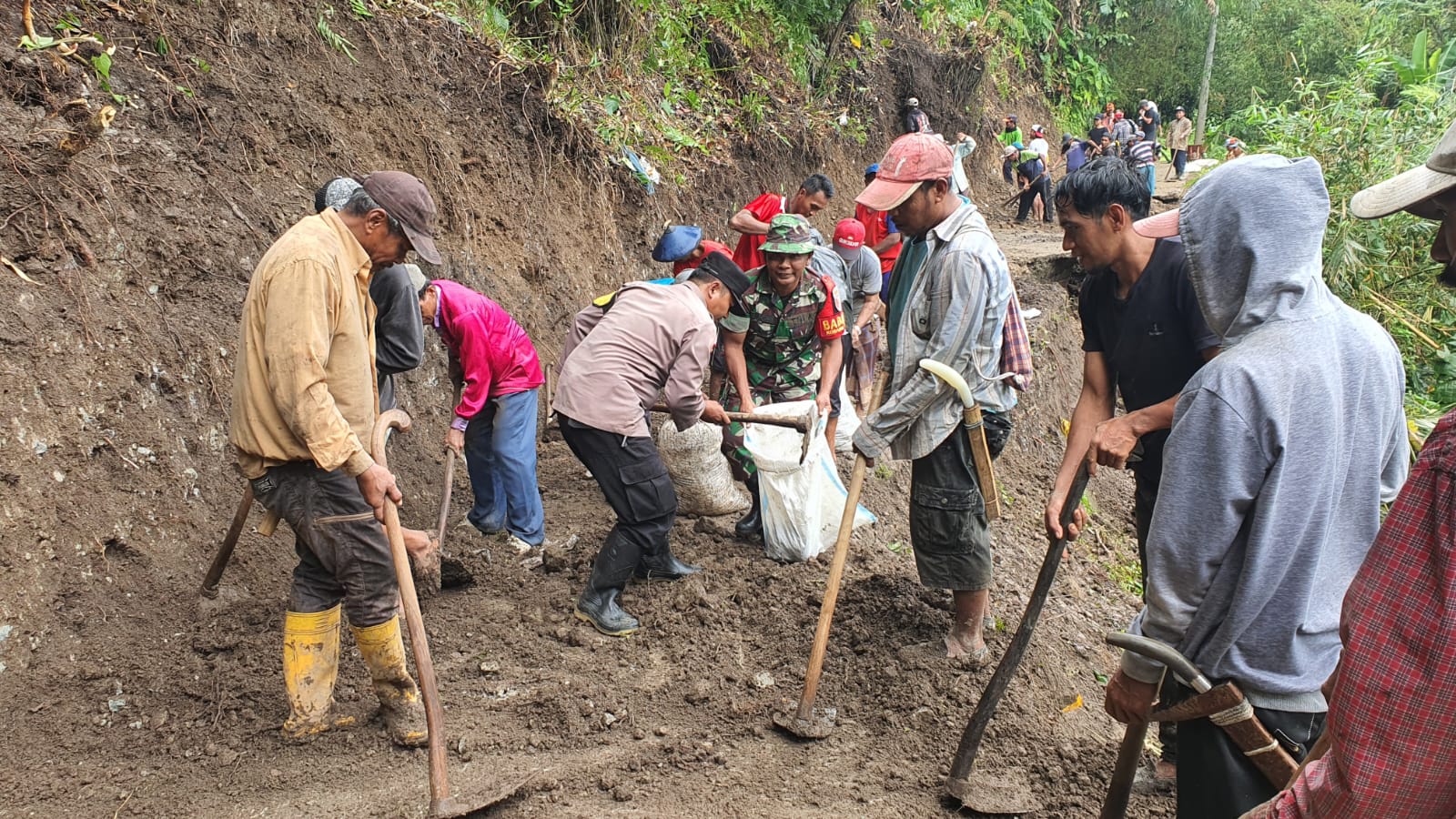Bersama dengan warga, personel Polsek Sangkapura lakukan pembersihan material akibat bencana alam tanah longsor di Dusun Serambah Desa Kebuntelukdalam Kecamatan Sangkapura Kabupaten Gresik, Minggu (29/01/2023).
