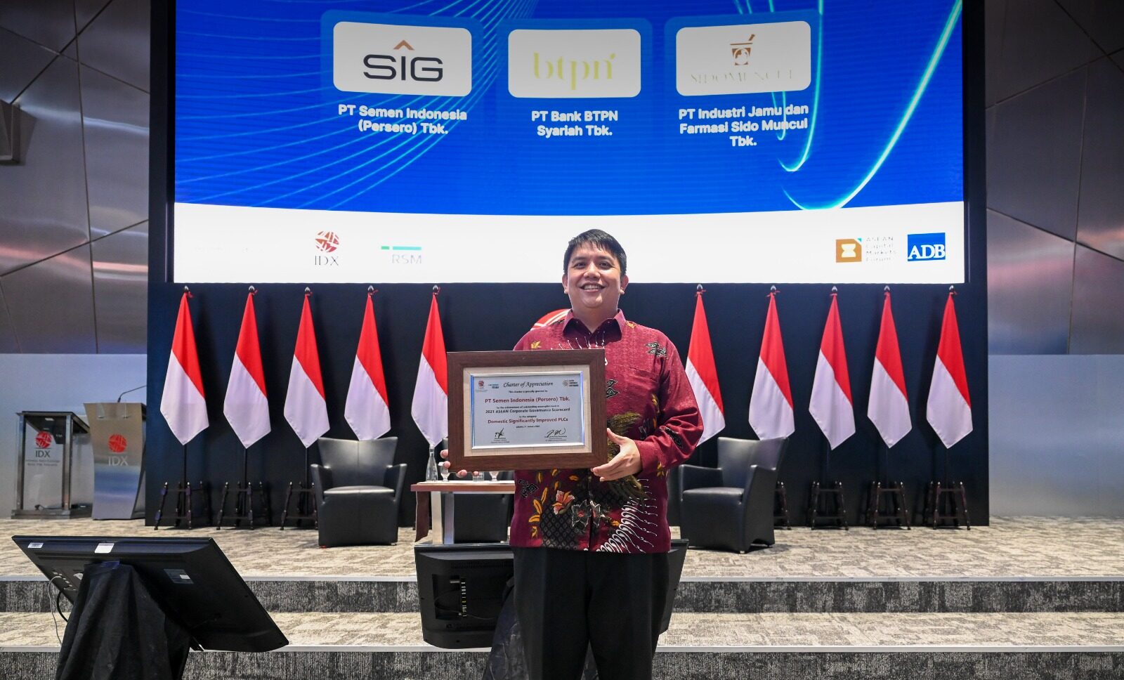 SVP of Legal, Governance & Compliance SIG, Maralda H. Kairupan membawa piagam penghargaan ASEAN Corporate Governance Scorecard Tahun 2021, di Main Hall PT Bursa Efek Indonesia, Jakarta, Selasa (31/1).