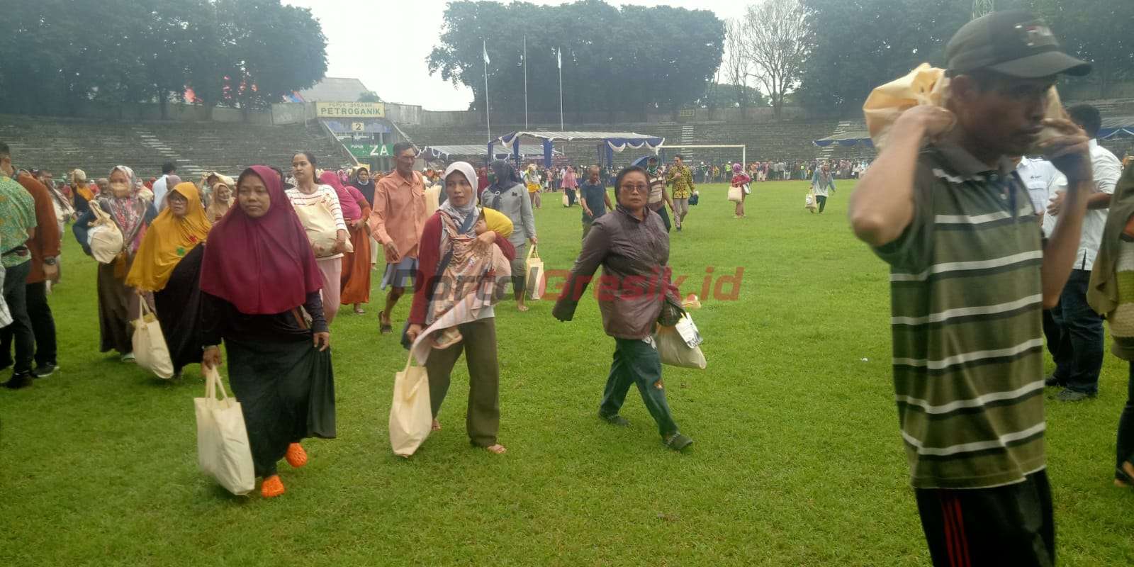 Warga sekitar perusahaan saat membawa paket sembako murah dalam Pasar Rakyat dan Bazar UMKM di Stadion Tri Dharma Gresik, Kamis (02/03/2023)