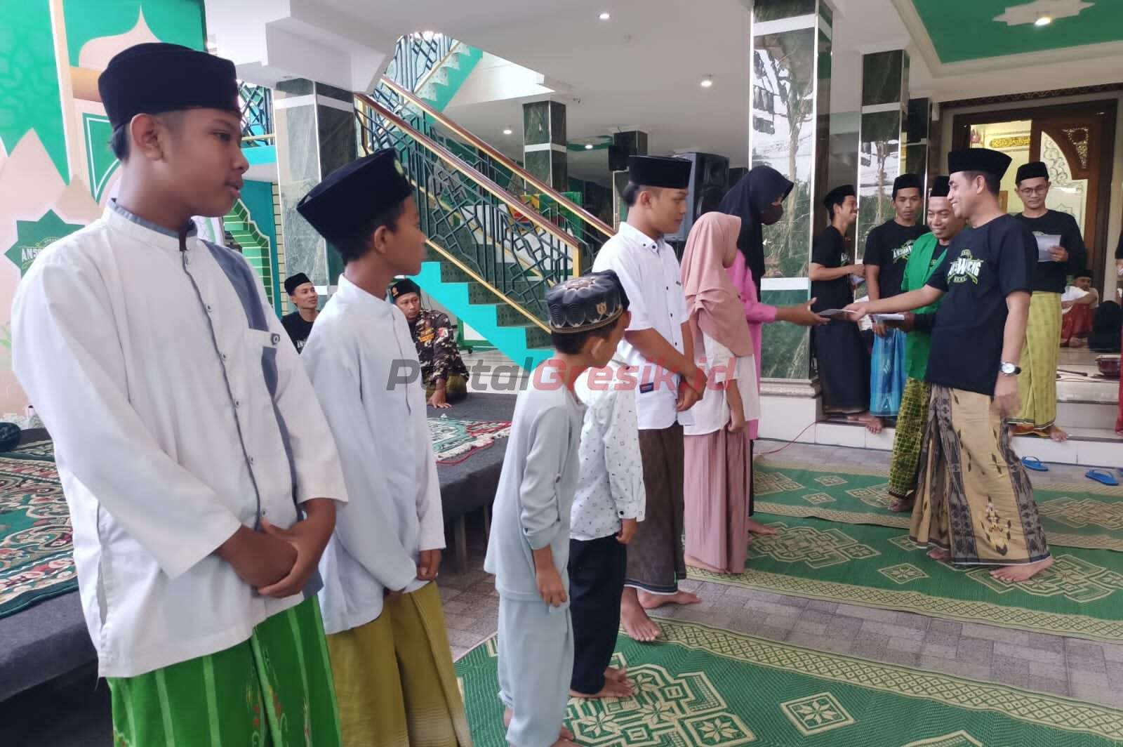 Pimpinan Ranting Gerakan Pemuda (GP) Ansor Desa Wadeng Kecamatan Sidayu Gresik saat simbolis memberikan santunan kepada anak yatim piatu, Selasa (18/04/2023).