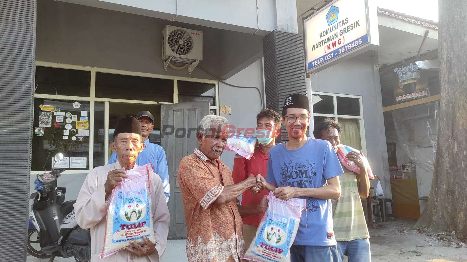 Sekretaris Komunitas Wartawan Gresik (KWG) saat menyalurkan beras kepada Abang becak yang mangkal di sekitar Bandar Grisse, Rabu (19/4/2023).