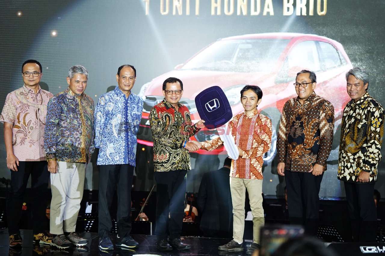 Direktur Utama SIG, Donny Arsal (kiri) memberikan hadiah doorprize utama kepada pemilik Toko Bangunan Bromo Mas, Muhammad Syukron (kanan), di Ballroom Shangri-La Hotel, Surabaya, pada Jumat (17/11/2023).