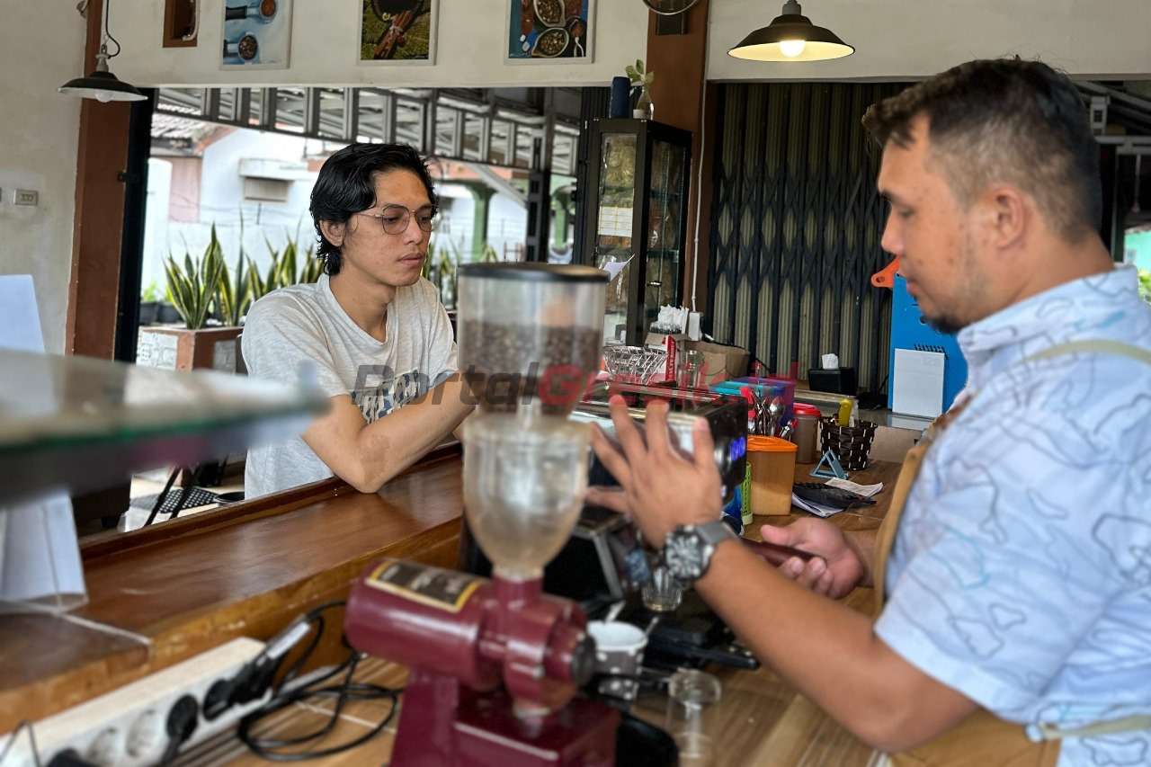 Deni Saputra meracik kopi untuk pelanggan di kafe Ngupi Ku-day miliknya di Baturaja, Sumatra Selatan.
