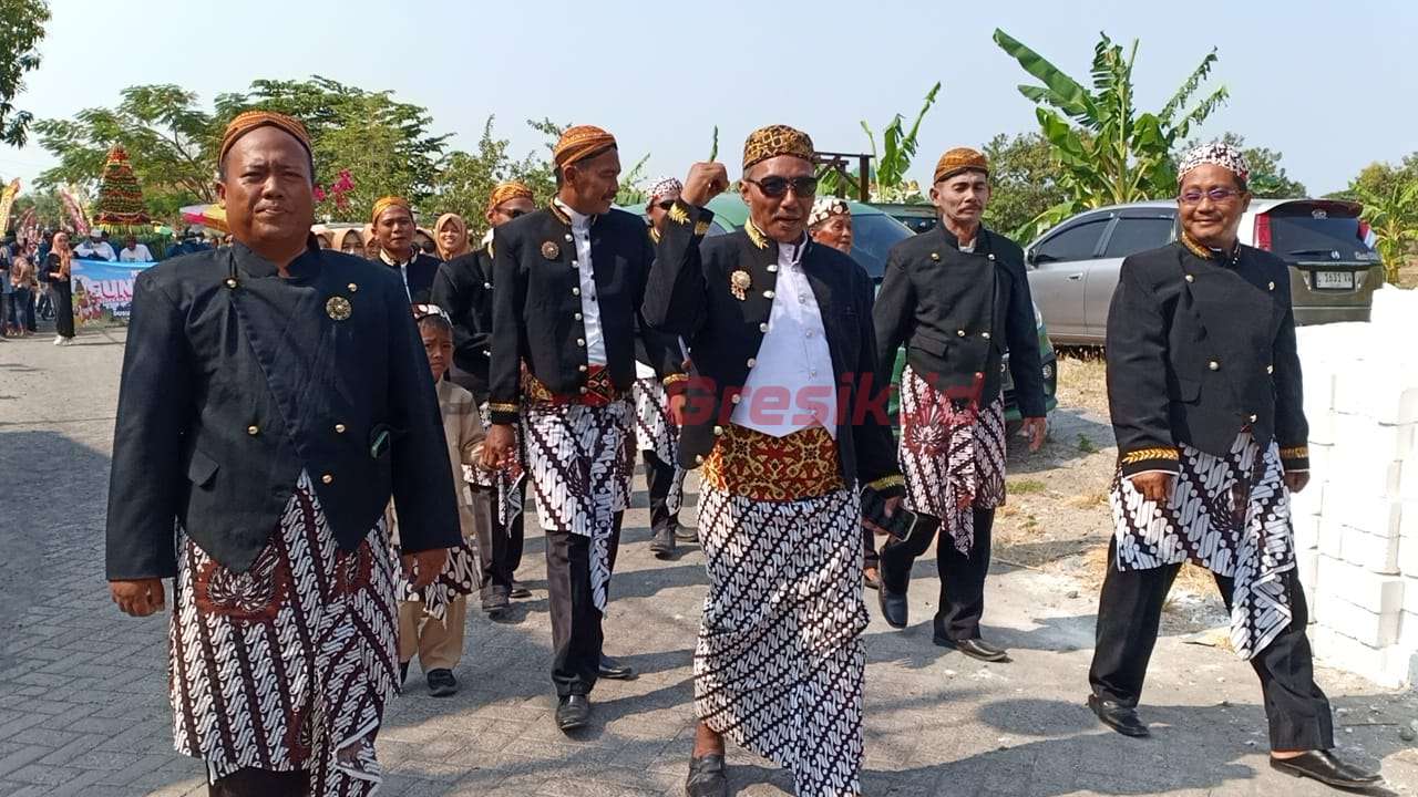 Kepala Desa Guranganyar Sariyadi (Pakai Blankon Berkacamata), Kecamatan Cerme, Kabupaten Gresik, Jawa Timur, saat bersama ribuan warga masyarakat menggelar kegiatan sedekah bumi, minggu(1/9/2024).