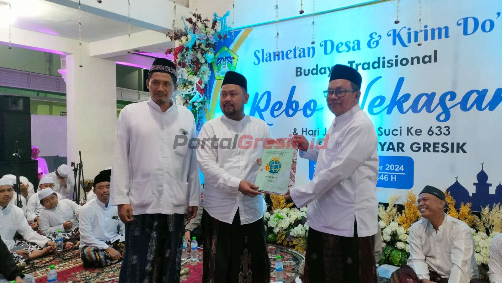 Bupati Gresik, Gus Yani (tengah) menyerahkan sertifikat TKD saat hadiri peringatan Rebu Wekasan Desa Suci.