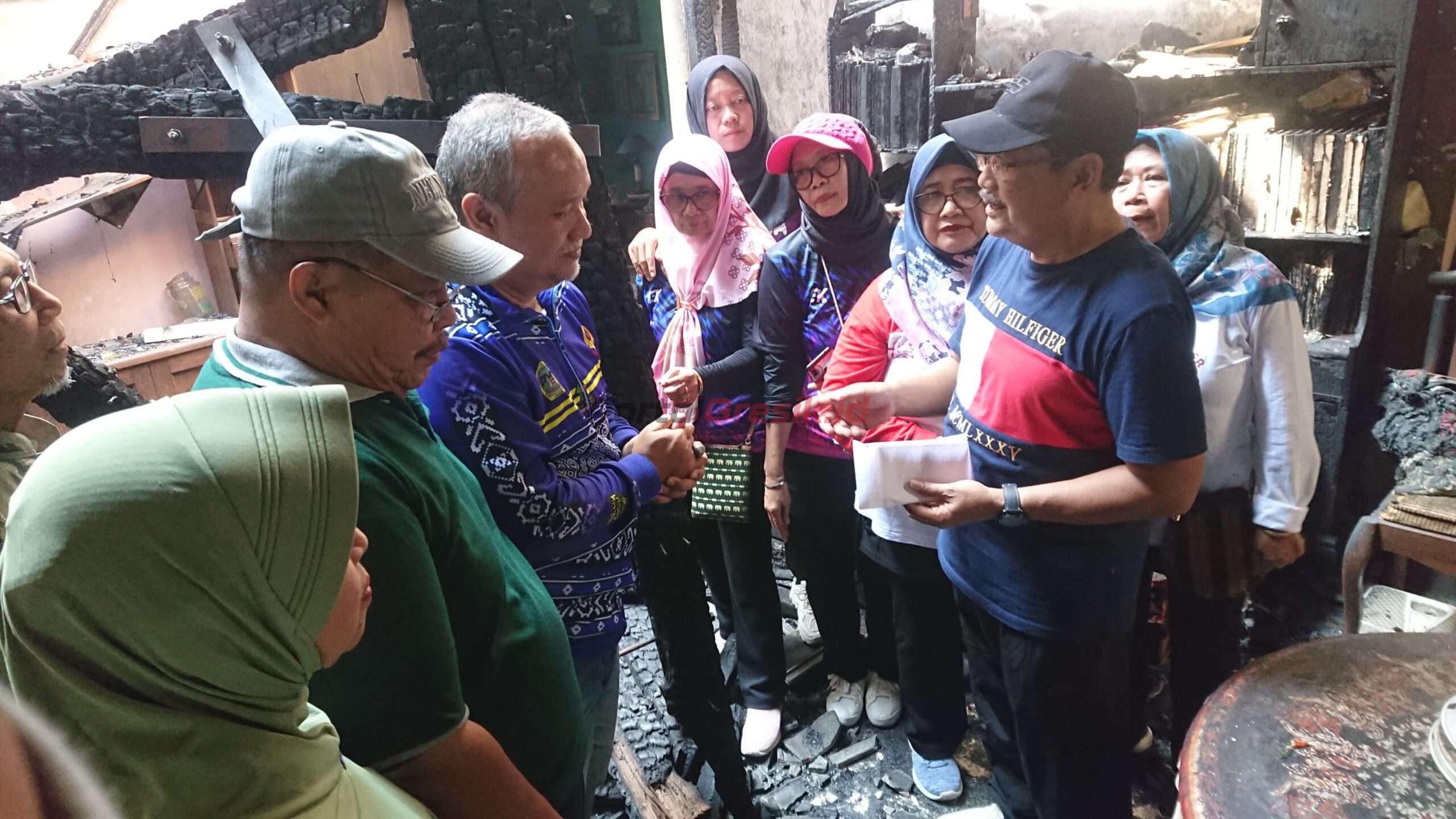 Kepala Desa (Kades) Randuagung, Khambali beserta perangkat desa mendatangi kediaman korban kebakaran bernama Masruroh (76) di Jalan Cimanuk No. 37 RT 3 RW 5 Desa Randuagung, Kecamatan Kebomas, Kabupaten Gresik, Jumat, (8/9/2024).