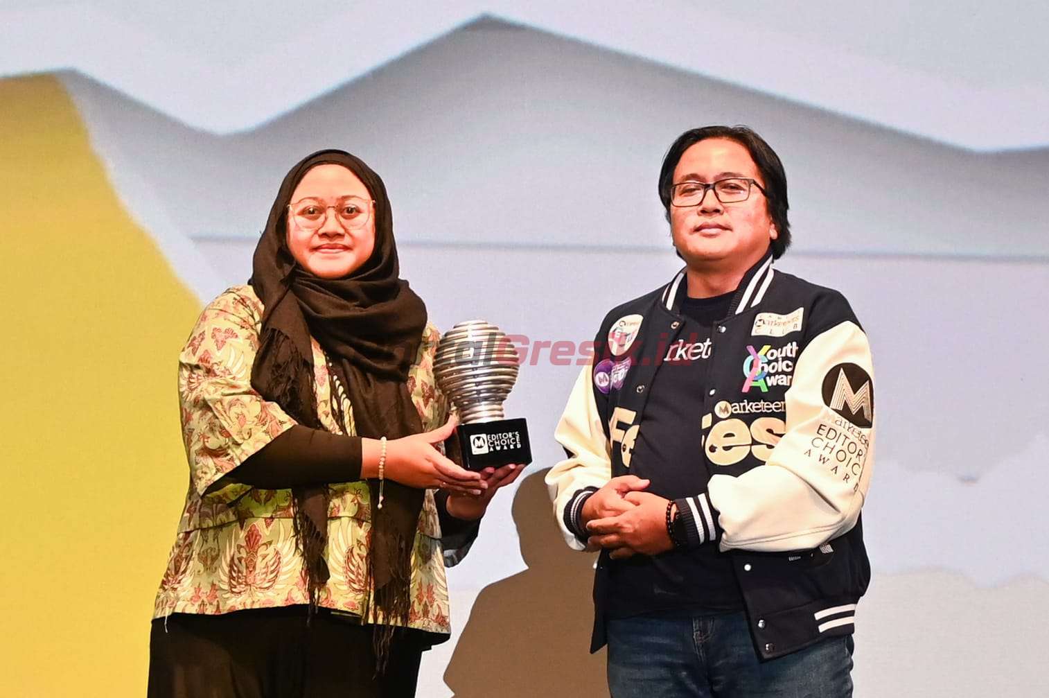 GM of Brand Management SIG, Sasha Media (kiri) menerima trofi penghargaan Customer Engagement Program Of The Year yang diserahkan oleh Editor in Chief Marketeers, Sigit Kurniawan (kanan) di The Ballroom at Djakarta Theater, Kamis (12/9/2024).