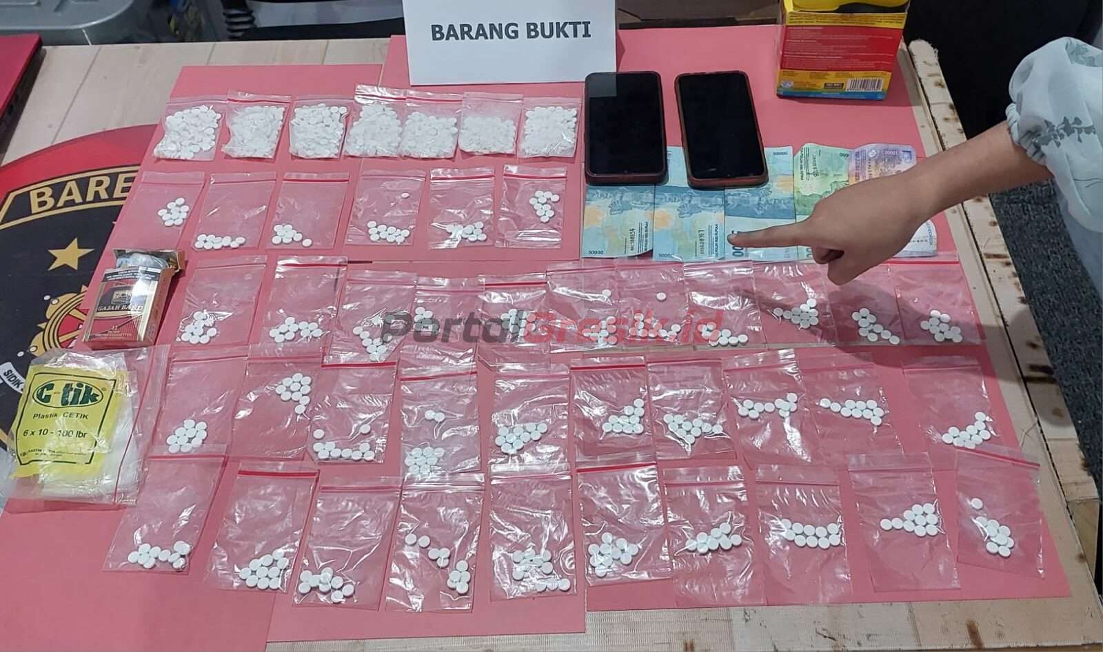 Barang bukti 37 klip isi 10 butir pil dobel L dengan total 370 butir, kemudian tujuh klip isi 100 butir pil dobel L dengan total 700 butir, uang tunai sebesar Rp 180 ribu