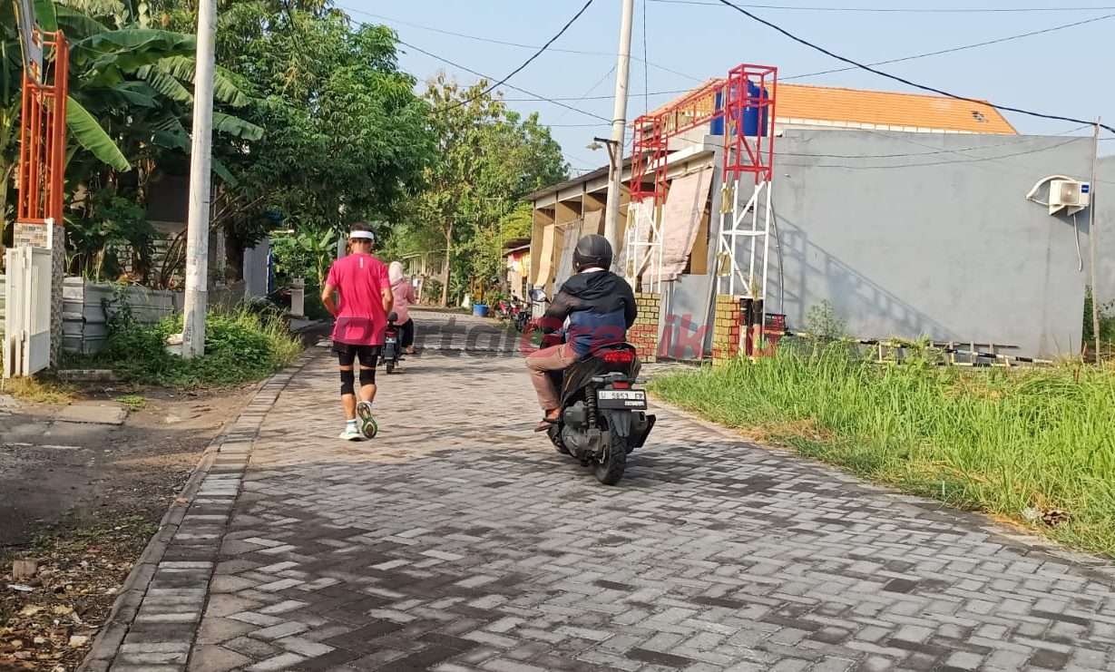 Warga tengah berolahraga dan berkendara di jalan paving Desa Kembangan.