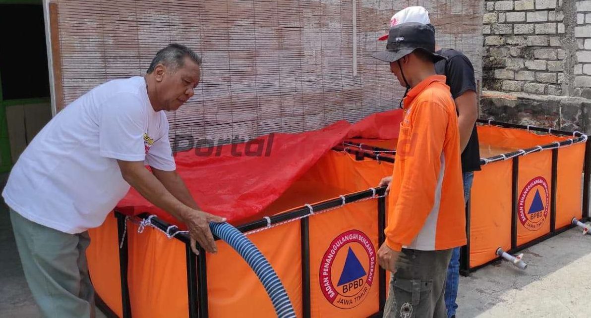 Petugas BPBD Kabupaten Gresik didampingi perangkat Desa mengisi tandon air bersih di Desa Boteng Kecamatan Menganti, Jumat (18/10/2024).