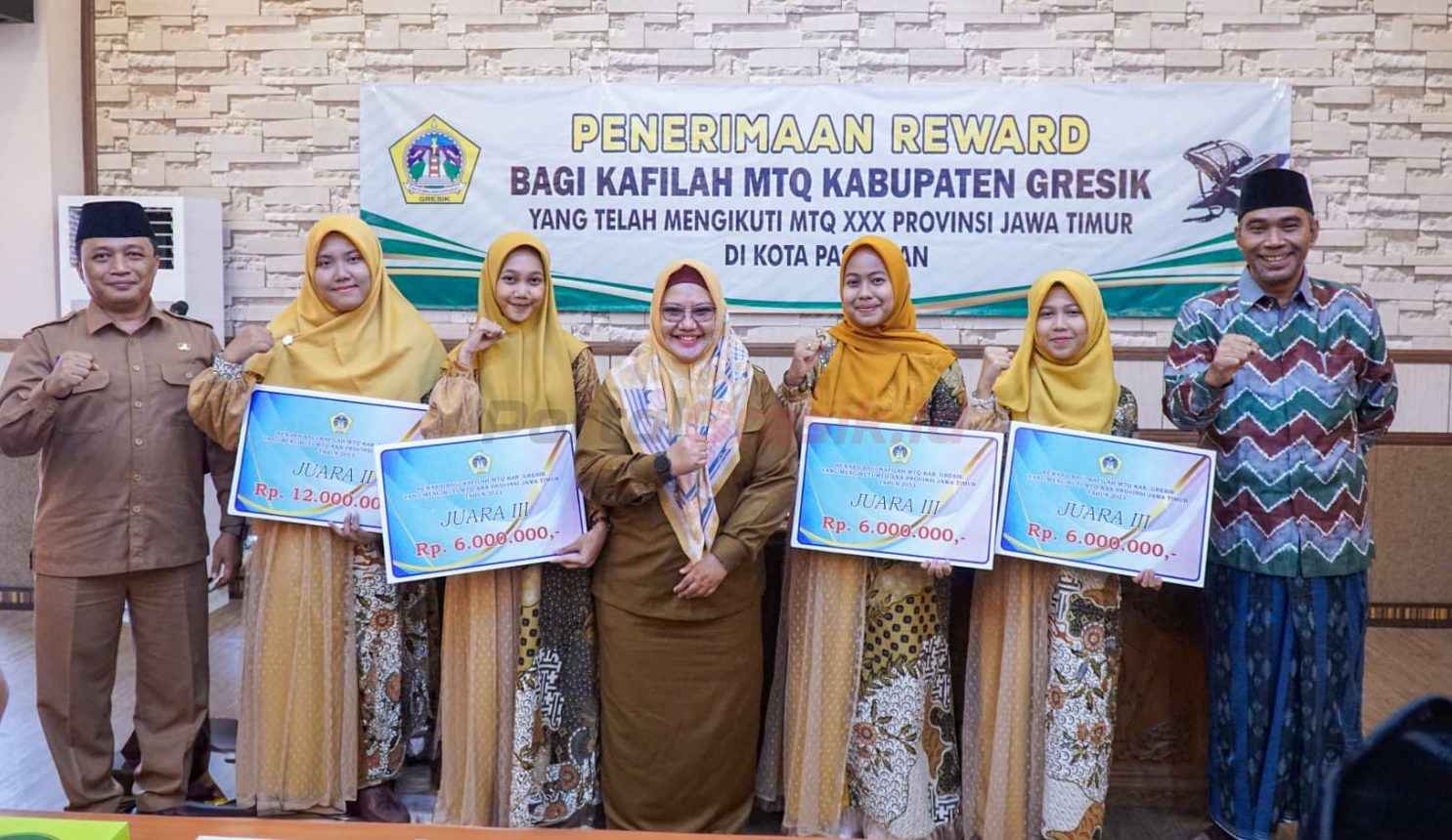 Bupati Gresik, Aminatun Habibah, menyerahkan penghargaan kepada Kafilah Kabupaten Gresik yang telah berprestasi di ajang Musabaqah Tilawatil Quran (MTQ) ke-30