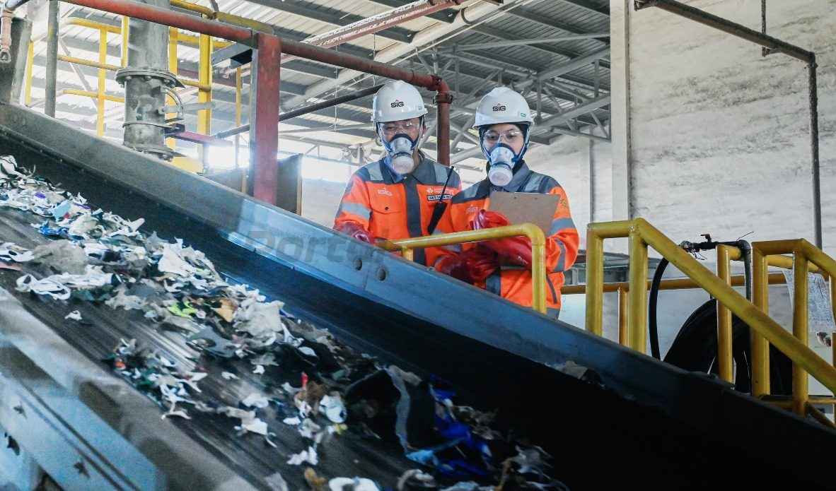 Karyawan SIG melakukan pengecekan material (Refused-Derived Fuel) yang akan dicacah untuk dimanfaatkan menjadi bahan bakar alternatif di area green zone Pabrik Narogong, Jawa Barat.