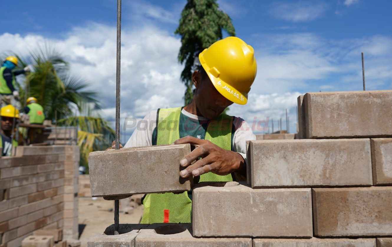 Proses pemasangan inovasi produk turunan semen hijau SIG precise interlock brick dalam pembangunan hunian tapak rumah lingkungan tipe 36 di kawasan Ibu Kota Nusantara (IKN).