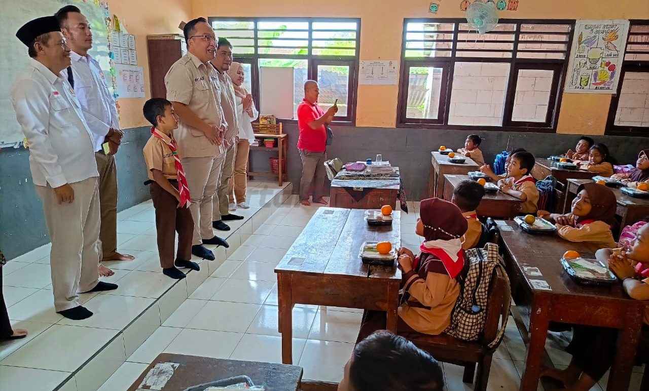 Ketua DPC Gerindra Gresik Asluchul Alif, saat membagikan membagikan MBG ke siswa UPT SDN 193 Desa Banyuurip..