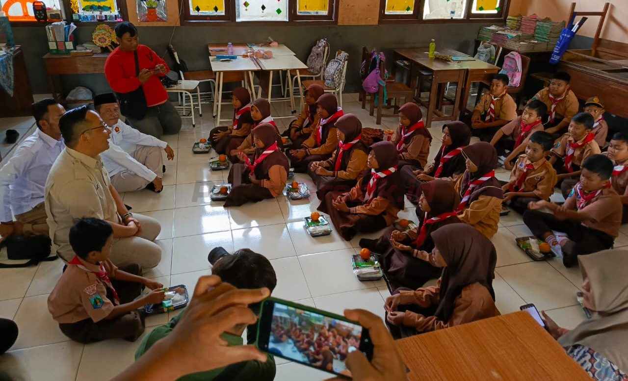Ketua DPC Gerindra Gresik Asluchul Alif, saat membagikan membagikan MBG ke siswa UPT SDN 193 Desa Banyuurip..
