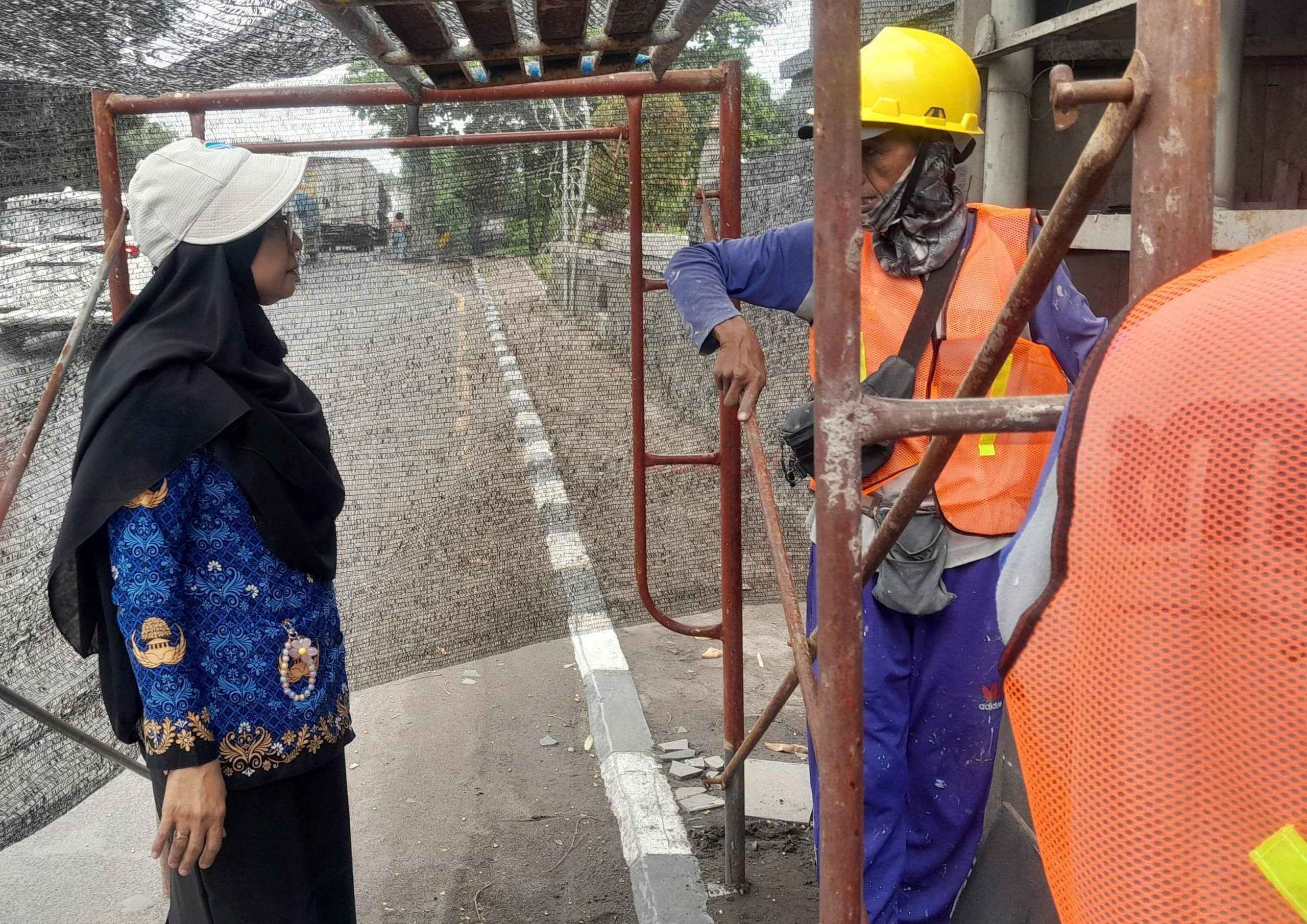 Kepala Dinas Dinas Lingkungan Hidup (DLH) Kabupaten Gresik Siti Subaidah saat melakukan pengecekan perbaikan bagian dinding Gapura Tugu Selamat Datang Perbatasan Gresik - Surabaya yang rusak.
