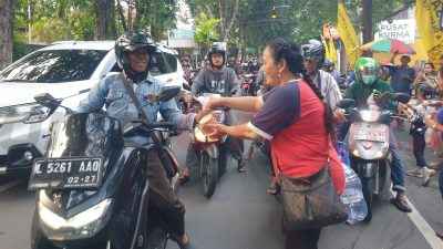 Umat Kristiani Gereja Bethel Indonesia (GBI) Rock Gresik saat bagikan takjil bagi pengendara di Jl. Panglima Sudirman, Kamis (6/3/2025) sore.