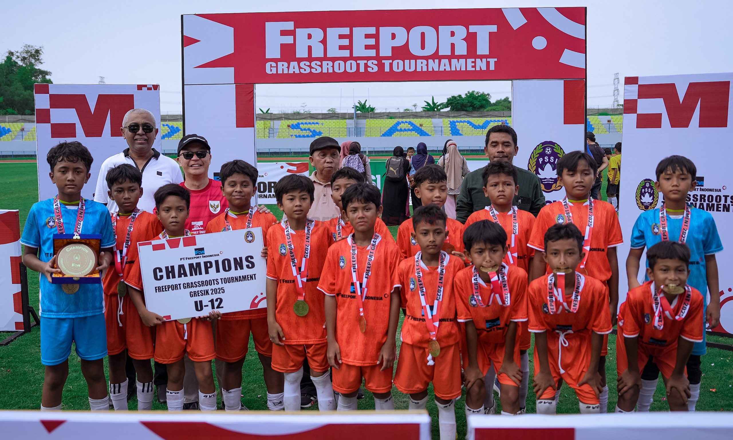 (Ki – ka belakang) Exco PSSI Ahmad Riyadh, Vice President Business Process Smelting dan Refining PTFI Aripin Buman, Asprov PSSI Jatim, Djoko Tetuko Sekum, Asosiasi Kabupaten PSSI Gresik Moh. Rofiqi berfoto bersama pemenang U-12 FGT 2025 di Gresik, SSB Sindogres.