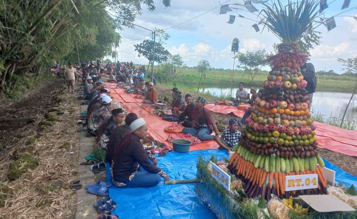 Gunungan hasil.bumi dan aneka makanan dibawa warga Sekargeneng saat sedekah bumi.