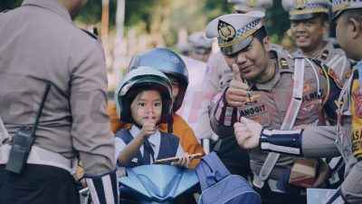 Satlantas Polres Gresik gelar Operasi Patuh Semeru 2025 secara humanis dengan cara membagikan helm gratis terutama kepada anak-anak, di simpang empat traffic light depan Pos 12.0 GKB, Jalan Dr. Wahidin Sudirohusodo, Setingi, Randuagung, Kecamatan Kebomas, Senin pagi (21/7/2025),