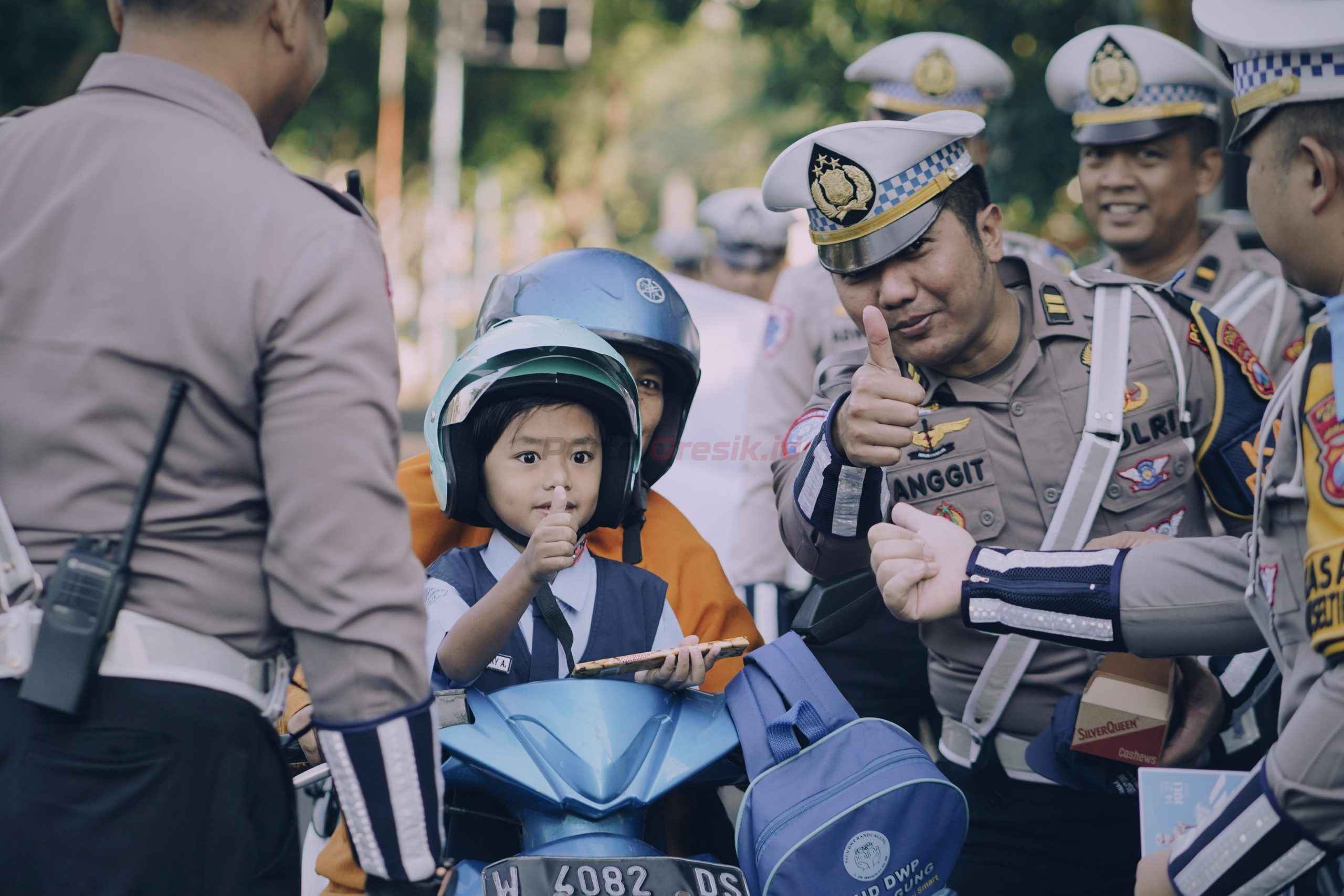 Satlantas Polres Gresik gelar Operasi Patuh Semeru 2025 secara humanis dengan cara membagikan helm gratis terutama kepada anak-anak, di simpang empat traffic light depan Pos 12.0 GKB, Jalan Dr. Wahidin Sudirohusodo, Setingi, Randuagung, Kecamatan Kebomas, Senin pagi (21/7/2025),