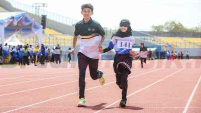 Atlet disabilitas netra berlari didampingi oleh guide runner yang menunjukan semangat dan kekompakan untuk mencapai garis finish (13/8).