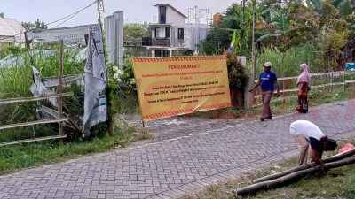 Ahli Waris pemilik tanah atas nama Sanusi P Adenan seluas 3.740 meter yang berlokasi di Dusun Nongkokerep RT 03 RW 01, Desa Bungah, Kecamatan Bungah saat memasang spanduk peringatan di area tanah yang berisi larangan mendirikan bangunan apapun, Minggu (3/8/2025).