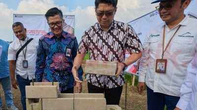 Direktur Keterbukaan Publik, Transparansi, dan Akuntabilitas, Kementerian PKP Brigjen Pol. Julisa Kusumowardono (kedua kanan) mempraktikkan penggunaan bata interlock presisi disaksikan Direktur Sales & Marketing SIG, Dicky Saelan (ketiga kanan) di perumahan Graha Asatu Puncak, Cibodas, Cianjur, Jawa Barat, pada Jumat (1/8/2025).